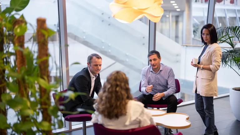 Four people in the office setting.